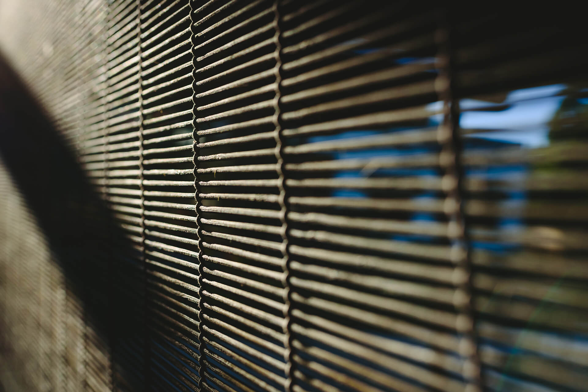 A window covered by natural wooden shades.